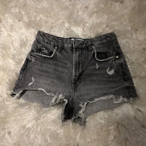 Grå jeansshorts zara - Grå jeansshorts från Zara med slitningar. Mycket bra skick!! Midjemått: 34cm