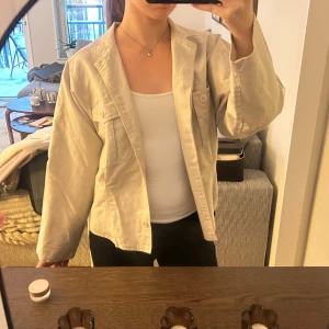 Beige jacka - Säljer en jättesnygg tunn beige jacka med två stora bröstfickor och knappar framtill. Jackan har en cool, avslappnad passform, perfekt att slänga över en t-shirt för en chill look. Jackan är sparsamt använd och i fint skick💗