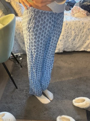 Blåmönstrade linnebyxor från Lindex - Säljer ett par superlätta och sköna blå linnebyxor från Lindex med snyggt mönster i mörkblått och vitt. Byxorna har resår i midjan och raka ben, perfekta för en chill och avslappnad stil.