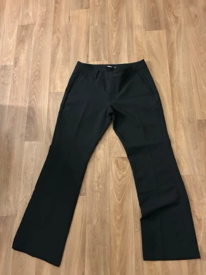 Svarta bootcut kostymbyxor BikBok från deras petite kollektion  - Snygga svarta kostymbyxor från BikBok i storlek 36. Byxorna har bootcut-modell och lågmidjade. Dem är från deras petite kollektion. Endast testade då dom inte passade i längden. 
