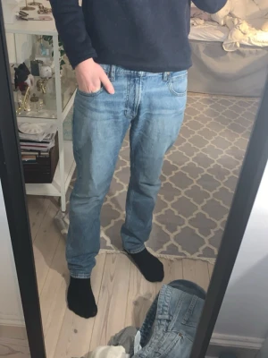  jeans straight fit Lee - W32 L32Säljer ett par klassiska ljusblå jeans från Lee med raka ben och normal passform. Jeansen har fem fickor, bälteshällor och Lee-lapp bak i brunt läder. Tillverkade i slitstark bomull med snygg tvättad look. Perfekta till en avslappnad stil.