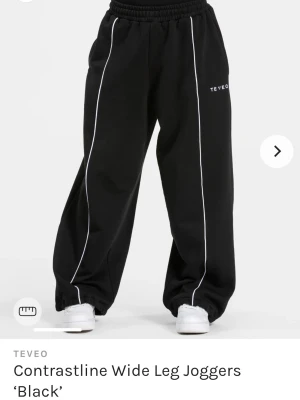 Teveo Contrastline Wide Leg Joggers  - Helt nya ouppackade sweatpants, svarta med vit smal rand. Slutsålda på Teveo. Jättesköna och snygga i mycket bra kvalitet (vet eftersom jag äger likadana i annan färg:) Oversized, 100% bomull, dragsko i midjan och vid foten. XS passar dig som är ca 163-168 cm lång.