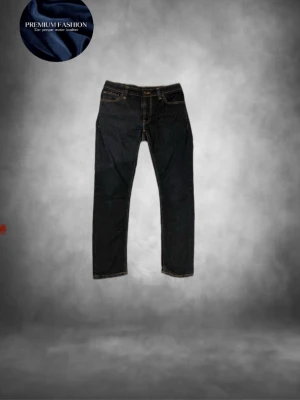 Nudie jeans mörkblå - Tja säljer nu ett par feta raw denim/mörkblå jeans från Nudie  med slim passform och klassisk femficksdesign. Jeansen har orange guldiga sömmar, knapp och dragkedja framtill  Perfekt för dig som gillar en clean och stilren look. Skicket är helt perfekt som nytt ungefär och storleken är w29 l30 passar dig som är runt 167-175 lång skulle jag tro!! Har du några övriga frågor är de bara att höra av sig🙌🏼mvh em_resell🤩