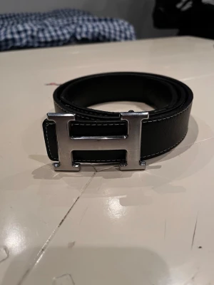 Svart H bälte - Bältet är defekt fast går fortfarande att andvända. 100cm. Hör av er vid minsta funderingar 