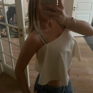 Beige volangtopp - Säljer en beige volang linnetopp med lös passform och tunna axelband. Toppen har en flowy och luftig design som ger en avslappnad vibe. Perfekt att matcha med jeans eller kjol för en chill look!💛💛