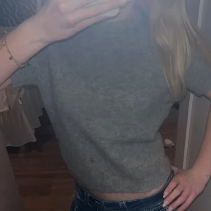 Grå stickad topp från Zara - Säljer en trendig grå stickad topp från Zara med korta ärmar och rund halsringning 🪩          Enkel att styla och passar perfekt till jeans Tjockare ull material som känns mjukt mot huden💘 