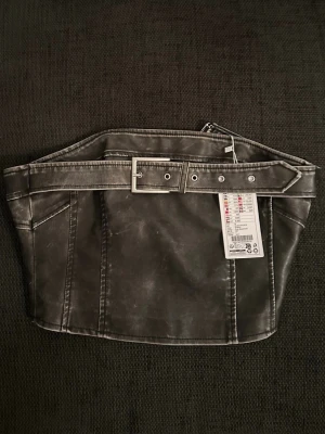 Topp med bältesdetalj - Topp med bältesdetalj, storlek medium. Helt ny med prislappen kvar, nypris 179kr