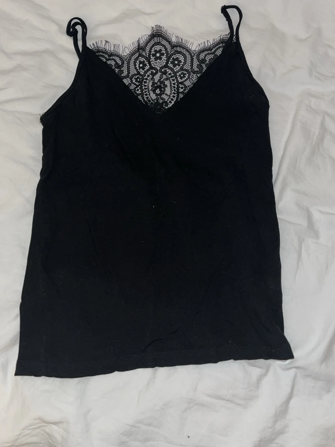 Svart linnetopp med spetsdetaljer