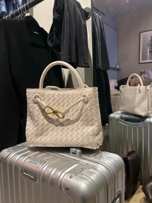 Elegant Woven Leather Handbag - Vacker flätad läderväska i en tidlös creme/beige färg. Väskan är ny utan prislapp och har aldrig använts. Högkvalitativt hantverk med stadig form, bekväma handtag och en stilren guldfärgad detalj framtill.  Perfekt storlek för vardag eller resa – rymmer allt du behöver samtidigt som den ser elegant ut. Lätt att matcha med både avslappnade och mer uppklädda outfits.  ✔️ Som ny ✔️ Högkvalitativt flätat läder ✔️ Stilren och minimalistisk design ✔️ Rökfritt hem