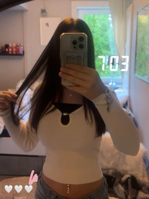 Vit ribbad långärmad topp med cut-out - vit ribbad topp med lång ärm och en unik cut-out detalj framtill. Inga skador, säljs pga att jag inte använder den