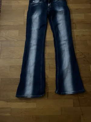 Blå bootcut jeans med slitningar - Säljer ett par cheap monday jeans med inga tecken på användning förutom att cheap monday lappen dör bak ör borta. 