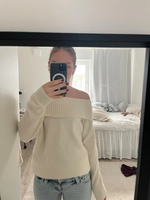 Offshoulder vit stickad tröja - Superfin offshoulder stickad tröja i vitt med bred ribbad kant upptill. Mjuk och skön. Har en liten gulaktig fläck, men syns inte när man viker ner kanten. Tröjan är ifrån Lindex och är i storlek 146-152 men passar mig som har 170