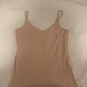 Ljusrosa linne med smala axelband - Säljer en enkel och stilren ljusrosa linne från lager 157. Toppen har smala axelband och en mjuk. Materialet är mjukt och luftigt