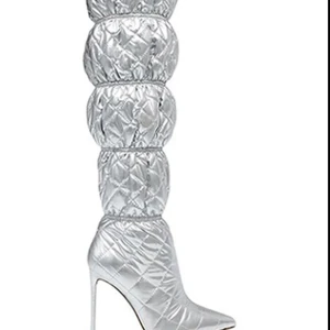 Steve Madden Silvriga quiltade stövlar med klack - Unika silvriga stövlar med quiltad design och hög klack. Stövlarna har en vadderad, puffig look och spetsig tå som verkligen sticker ut. Perfekta för dig som vill ha något extra till outfiten. UBRUKT - Nypris var 1695🌟