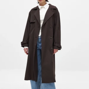 Brun trenchcoat NA-KD - Säljer denna helt nya oanvända långa kappan/trenhcoaten från NA-KD. Helt slutsåld, prislappen sitter kvar. Köpt för 1249 kr