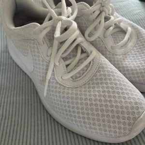 Vita mesh-sneakers från Nike - Säljer ett par vita sneakers från Nike. Perfekt som gym skor. Är i bra skick ända nackdelen är fläckarna på högra skon man ser på bilden. Det går att ta bort om man bleker dem. Hade inte använt dem många gånger men råkade gå i en lerpöl när jag var ute o sprang med dem.