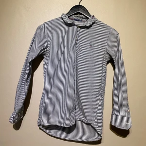 Randig skjorta  - Säljer denna skjorta från GANT i storlek 146/152 motsvarar XS. Materialet är bomull. Kan behövas en tvätt pga legat i flyttkartonger. Finns att hämta i centrala Göteborg eller kan skickas via valfri app. 