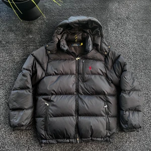 Svart pufferjacka från Polo Ralph Lauren - Svart pufferjacka från Polo Ralph Lauren med huva och klassisk röd logga på bröstet. Jackan har dragkedja framtill, två sidofickor med dragkedja och en bröstficka. Skick 7/10, väldigt bra skick förutom skadan som syns på sista bilden som sitter på baksidan av vänstra armen så den syns inte vid användning. Storlek L. Pris går att diskutera✅