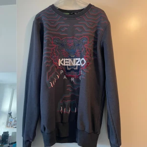 Mörkgrå Kenzo sweatshirt med tiger - Säljer en mörkgrå sweatshirt från Kenzo med ikoniskt broderat tigerhuvud och logga på bröstet. Storlek L 