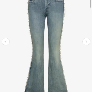 Blå bootcut jeans med olika färger - Snygga blå bootcut jeans med fransade sidor som ger en cool och unik look. Jeansen har klassisk femficksdesign och är tillverkade i denim. De är även 2 olika färger på framsidan och baksidan