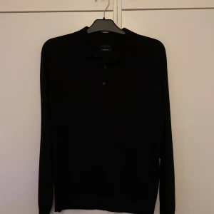 Merinoull pikétröja Massimo Dutti - Stilren svart pikétröja från Massimo Dutti i 100% merinoull. Använd endast en gång.