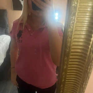Rosa USPA pikétröja med tryck - Säljer en rosa pikétröja från US Polo Assn med krage 