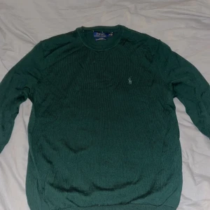 Grön merinoullströja Polo Ralph Lauren - Mörkgrön stickad tröja från Polo Ralph Lauren. Är helt nyt skick i passformen slim fit med klassisk rund hals och broderad logga på bröstet. Tillverkad i mjuk och tvättbar merinoull, perfekt för lager-på-lager under höst och vinter.