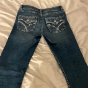 Blå jeans med broderade bakfickor - Snygga blå jeans med unika broderade detaljer på bakfickorna. Klassisk femficksmodell och raka ben. Perfekta för dig som vill ha ett par jeans med lite extra stil.