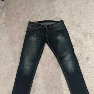 Mörkblå Dondup jeans med slitningar - Snygga mörkblå jeans från Dondup med slitna detaljer och kontrastsömmar. Klassisk femficksmodell med låg midja och raka ben. Jeansen har en cool tvätt och är tillverkade i mjukt denimtyg som sitter skönt hela dagen.