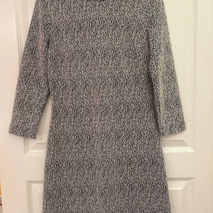 Mönstrad klänning från & Other Stories - Snygg svartvit mönstrad klänning från & Other Stories med trekvartsärm och rund hals. Materialet är en mix av bomull, polyester och elastan som ger en skön stretch. Klänningen har en rak passform och dragkedja i sidan för enkel påklädning.