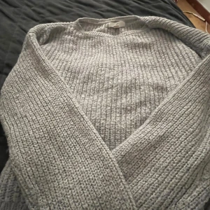 Grå stickad tröja från H&M - Mysig grå stickad tröja från H&M med rund halsringning och grov ribbstickning. Perfekt för kyliga dagar och enkel att matcha med jeans eller kjol. Långärmad och i en klassisk, avslappnad passform!!.🩵🩵