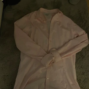 Ljusrosa skjorta från Jack & Jones - Säljer en stilren ljusrosa skjorta från Jack & Jones. Skjortan har klassisk krage, långa ärmar och knäppning framtill. Perfekt för dig som gillar en clean och enkel look. Materialet är mjukt och skönt bomullstyg.