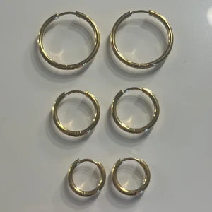Set med tre par guldiga örhängen - Säljer ett set med tre par klassiska guldörhängen. Stainless steel