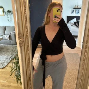 Pilateströja  - Säljer en svart omlottopp från Even&Odd Active i storlek M. Toppen har lång ärm, croppad passform och knyt i midjan. V-ringad framtill och tillverkad i mjukt material som sitter snyggt på kroppen. Perfekt för dig som gillar stilrena och trendiga plagg.  Säljer pga för stor!