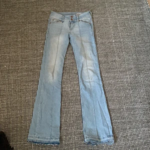 Ljusblå bootcut jeans från Bershka - Säljer ett par ljusblå jeans från Bershka i storlek 34. Modellen har bootcut o midwaist. klassiska fem fickor. Jeansen är i mjukt denimtyg och har snygga söm-detaljer framtill. Perfekta för dig som gillar en retro vibe. Har spretat upp dem där nere 