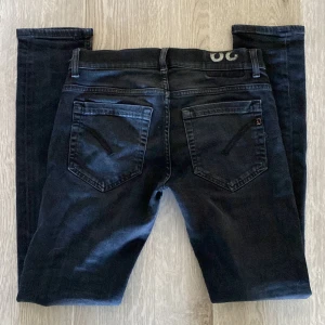 Svarta skinny jeans från dondup - Snygga mörkblå skinny jeans från dondup med klassisk femficksdesign och diskreta detaljer. Jeansen har smal passform och är tillverkade i stretchigt denimtyg för en bekväm känsla. Perfekta för dig som gillar en tajt siluett och stilren look.