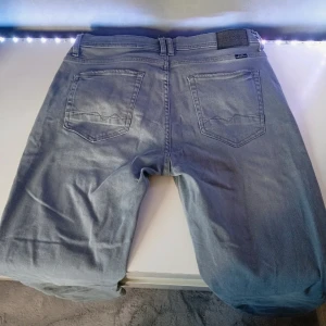 Grå jeans från Blend  - Snygga grå jeans från Blend  raka ben och normal passform stilrena med diskreta slitningar för en cool, avslappnad look 😎 Tillverkade i mjukt och bekvämt jeanstyg av hög kvalitet. Nästan aldrig använda! Nypris 799 kr 🏷️  Perfekta till både vardag och fest grym passform och tidlös färg som funkar till allt 🤍