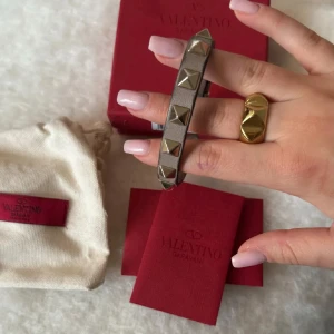 Valentino armband  - Jättefint armband från Valentino. Skicket är inte toppen men det funkar och går nog att fixa ännu bättre. Har testat limmat med ett lim där det har släppt som man kan se på tredje bilden men inte gått så bra. Endast armband och extra nitar medföljer. Nypris är ungefär 3 000💞 första bilden är lånad💕