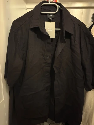 Svart linneskjorta från H&M - Svart pike från H&M i relaxed fit med halvlång ärm och klassisk krage. 