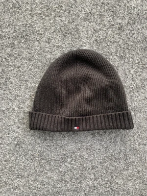 Tommy Hilfiger beanie  - Svart stickat Tommy Hilfiger beanie/mössa till mycket bra pris. Perfekt att köpa nu under black week inför vintern. Använd endast ett fåtal gånger. Size: Onesize.                                                                          Hör av er vid eventuella frågor!!