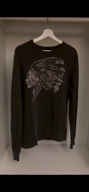 Svart tröja från Ralph lauren denim supply - Säljer en svart långärmad tröja från Denim & Supply Ralph med sjukt fett tryck. Tröjan är i storlek M och är i toppskick utan några skavanker. Om det finns några funderingar är det bara att fråga!