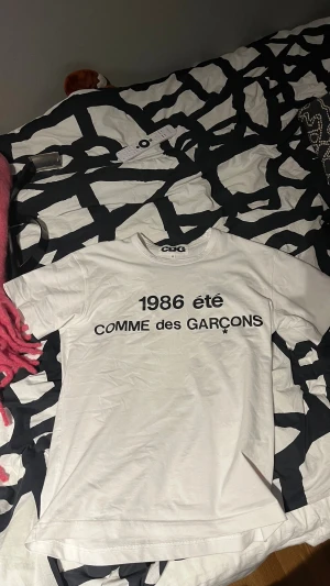 Vit Comme des Garçons t-shirt M - Tja! Säljer en sjukt fet T-Shirt ifrån Comme des Garçons. Väldigt eftertraktad men också limiterad. Passar till allting! Köp och va unik😃