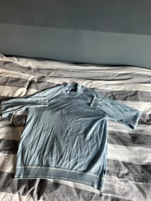 Ljusblå tröja från BOSS, storlek L - Snygg ljusblå tröja från BOSS i storlek L. Tröjan har ribbade muddar vid hals, ärmslut och nederkant samt diskreta vita ränder på ärmar och nederkant. Tillverkad i mjuk bomull, perfekt för vår och sommar. Enkel och clean design som funkar till många stilar. Kom privat vid bild på 