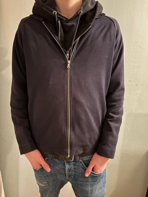 Overshirt från H&M - Blå overshirt från H&M med hel dragkedja framtill och huva. Tröjan har en enkel, clean look med långa ärmar och normal passform. Tillverkad i mjuk bomullsmix som är skön att bära. Perfekt för chill dagar eller när du vill ha en avslappnad stil. Riktigt fet, modellen är 183 o väger 68