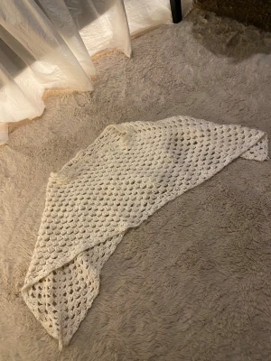 Vit virkad  - En vit slags tröja i utan armar som man kan ha över axlarna. Den har ett luftigt och öppet mönster. Perfekt att slänga över axlarna för extra värme och stil. Materialet känns som bomull eller ull och är knappt använd💞vet inte riktigt storleken men skulle säga att den passar mellan storlekarna XS till M
