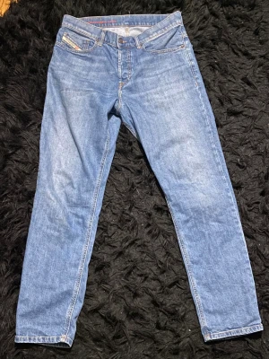 Blå jeans från Diesel Industry - Säljer ett par klassiska blå jeans från Diesel Industry med raka ben och snygg look i storlek 30/32. Perfekta för dig som gillar stilrena och tidlösa denimbyxor. Endast använd 1-2 gånger och är i princip nya. 