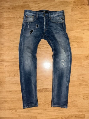 Replay anbass  - Ett par schyssta anbass jeans i storleken W30 L32. Soft längd på bena med en grym öppning vid änden. Jeansen sträcker sig fint runt låren men med en bekväm passform. Har du en funderingen hör av dig, MVH LUNDGRENS 