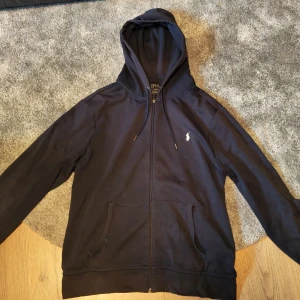 Mörkblå zip hoodie från Polo Ralph Lauren - Snygg mörkblå hoodie från Polo Ralph Lauren med dragkedja endast lite slitage vid ärmarna 