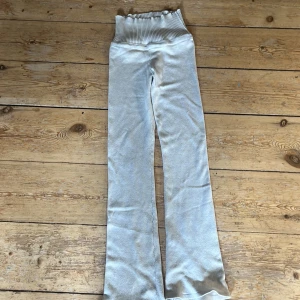 Beiga ribbade byxor från Gina Tricot - Supermysiga beiga byxor från Gina Tricot med bred ribbad midja och raka ben. Byxorna är stickade i mjukt material och har en högmidjad passform som sitter skönt. Perfekta för chill dagar eller när du vill vara extra comfy och dom är väldigt långa.