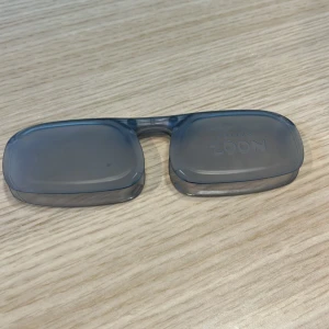 Blå rektangulära glasögon från Noon - Säljer ett par stilrena glasögon från Noon med rektangulära bågar i transparent blå plast. Perfekt för dig som gillar minimalistisk design och vill sticka ut med en modern look. Lätta och bekväma att bära hela dagen.